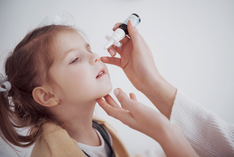 mom using nasal spray on bottle