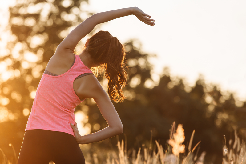 young female doing stretches before beginning exercise