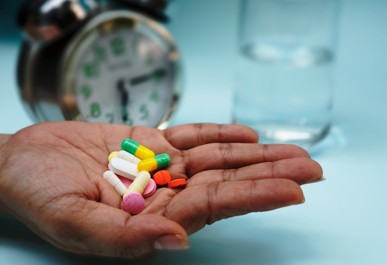 person holding multiple medications in hand