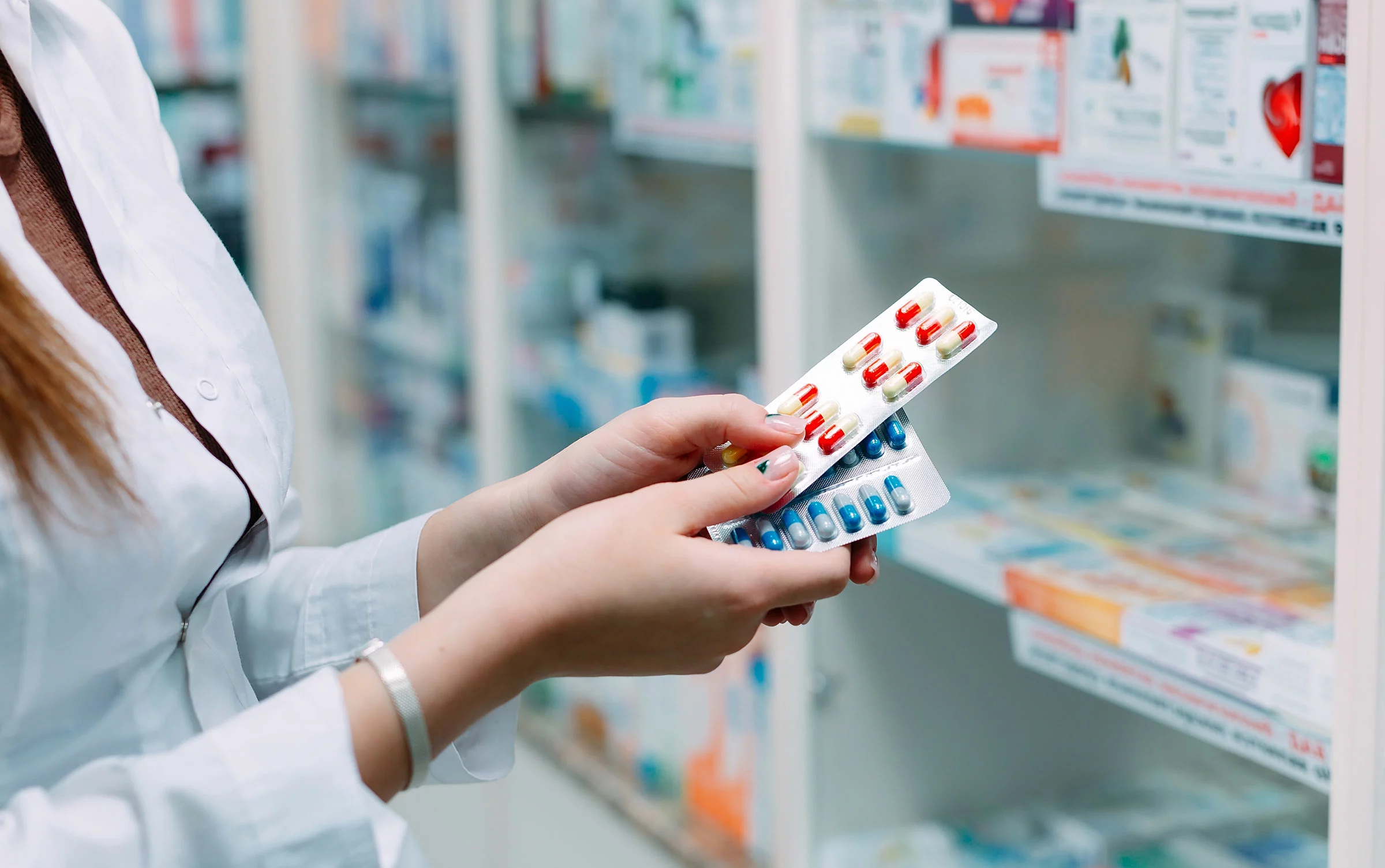 Pharmacist holding prescription pill packages