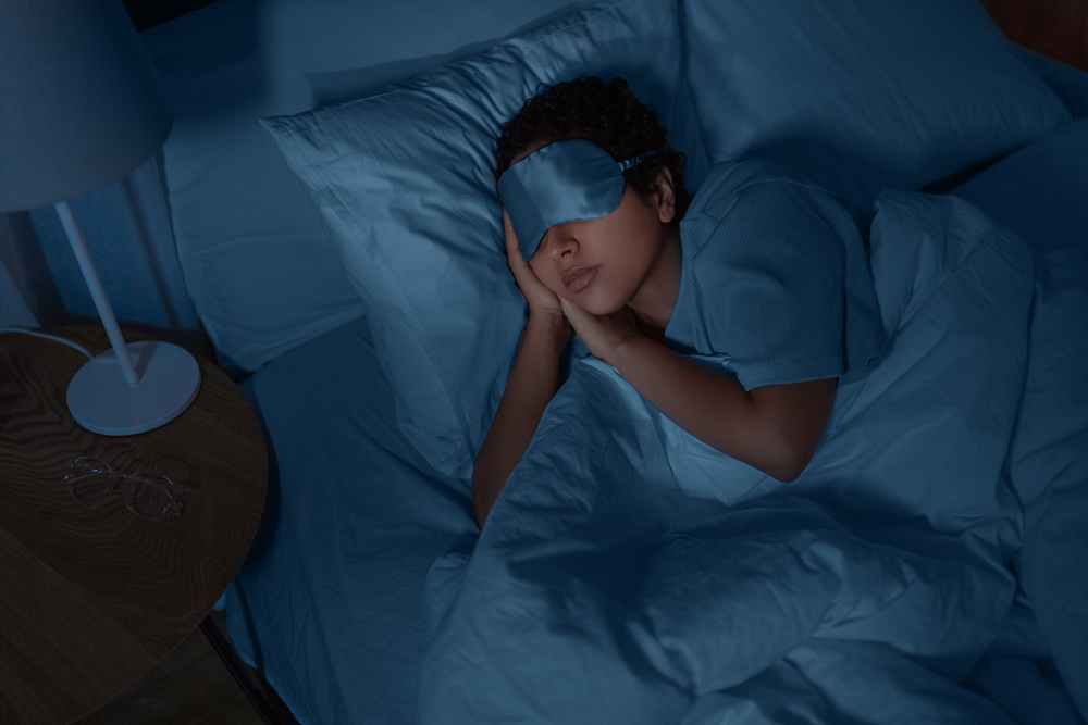 young woman sleeping with mask covering eyes