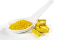 spoonful of yellow berberine powder next to berberine supplements