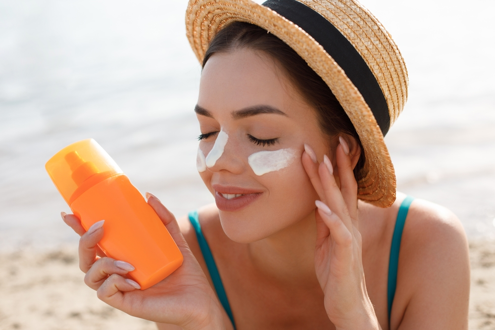 woman applying sunscreen to face