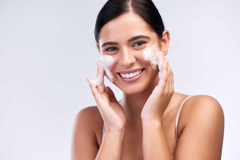 woman rubbing foam cleanser on cheeks